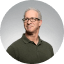 Circular headshot of a man on a teal background above a testmonial quote praising excelence in social media