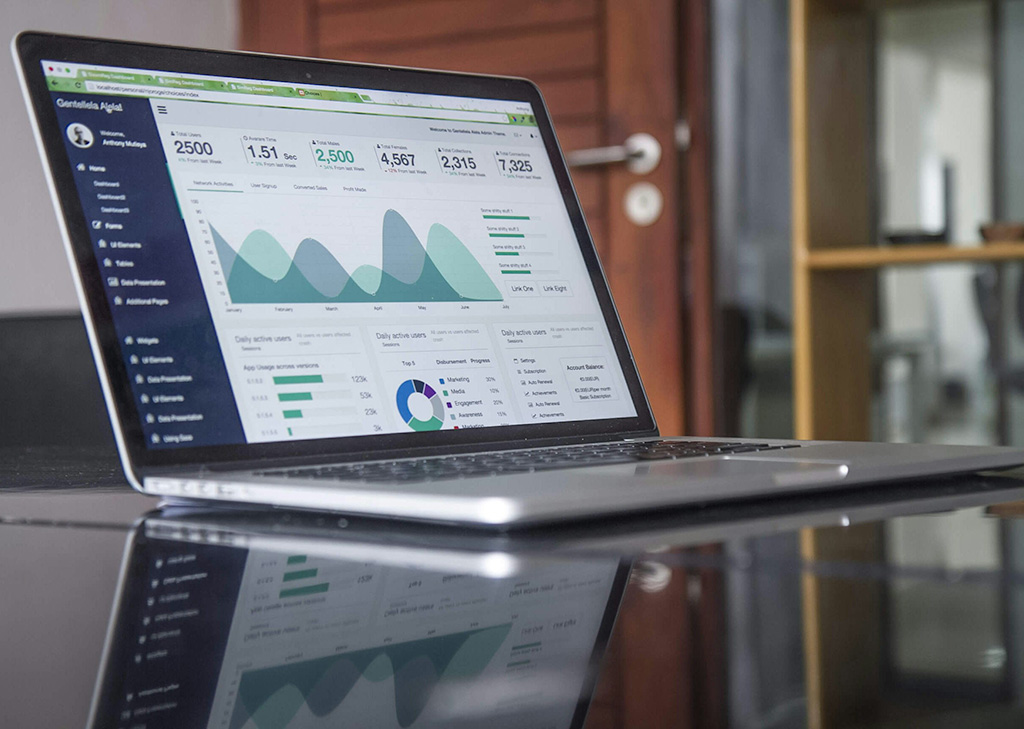 Laptop on a desk displaying website analytics and charts, representing web design and development focused on creating fast, functional, and user-friendly websites aligned with business goals